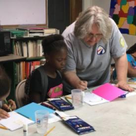 DeltaCorps Service Member Jo Taylor helps with an arts enrichment project at BAMA Kids