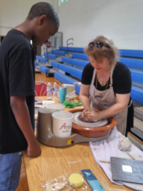 Kristin Law demonstrates throwing pottery to CSAT students