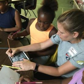 DeltaCorps Service Member Stephanie Wilkins demonstrates an arts enrichment project for BAMA Kids