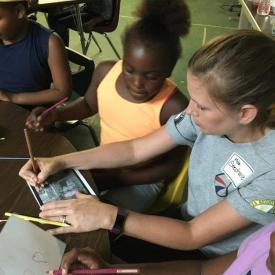 DeltaCorps Service Member Stephanie Wilkins demonstrates an arts enrichment project for BAMA Kids